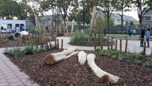 Speeltoestellen geïntegreerd in groen schoolplein.