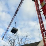 Watertank die wordt geplaatst met een hijskraan.