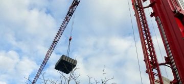 Watertank die wordt geplaatst met een hijskraan.