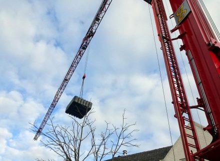 Watertank die wordt geplaatst met een hijskraan.